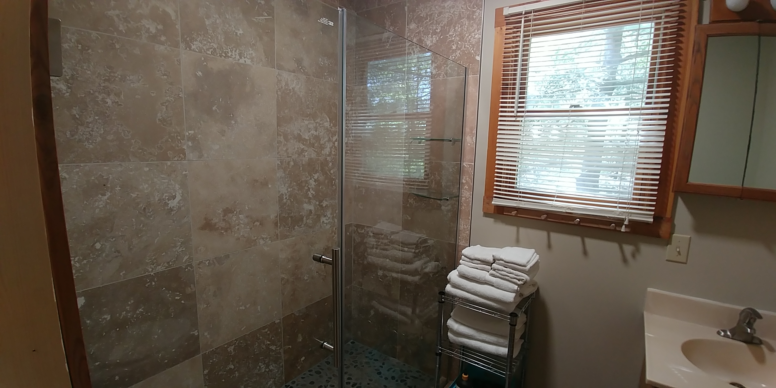 Photo 619_12204.jpg - Features walk in tile shower with glass doors, toilet and sink/vanity